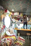 SCAD alumna and featured artist Trish Andersen sitting on the fold-up hammock bed, which accommodates the desk underneath, in one of the SCADpads. The fold-up hammock bed was designed and constructed 
