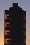 <p class='MsoNormal'>The tower's unique taproot core design is illuminated by a sunset.</p>