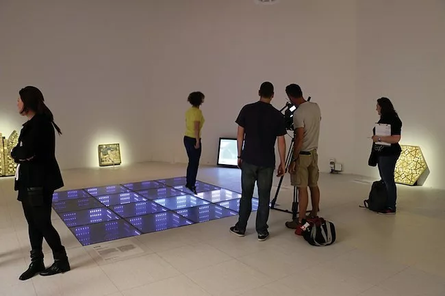 A visitor hops on a power-generating dance floor in the Floor gallery.
