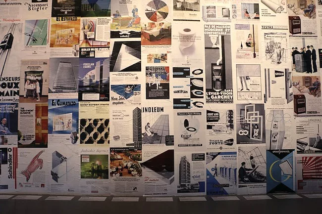 Advertisements for architectural materials line the walls in the introductory space.