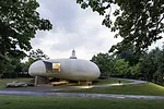 The semi-translucent, cylindrical structure was designed to resemble a shell resting on large quarry stones.