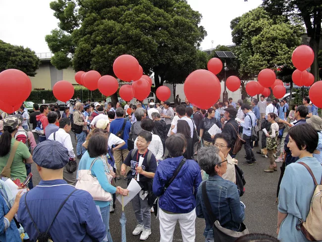 Protestors gather around the National Stadium on Saturday, hoping to save it from demolition.