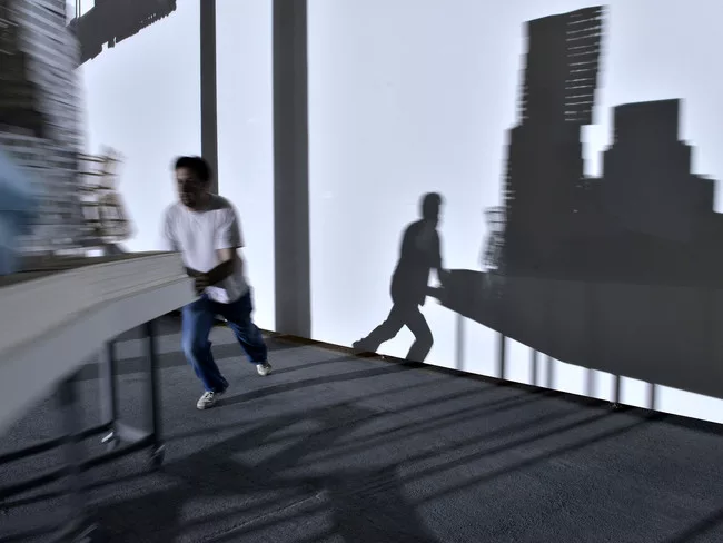 Perfromers push models of Frank Gehry's work around the exhibition according to a set of motions choreographed by artist Tino Sehgal.