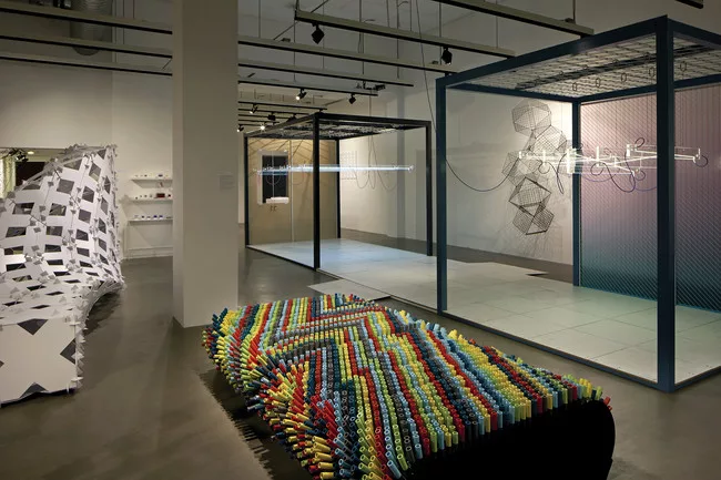 <em>Bench Press</em> by Leah Rosenberg and Matthew Rosenberg is made of multi-colored, striated rubber tubing.