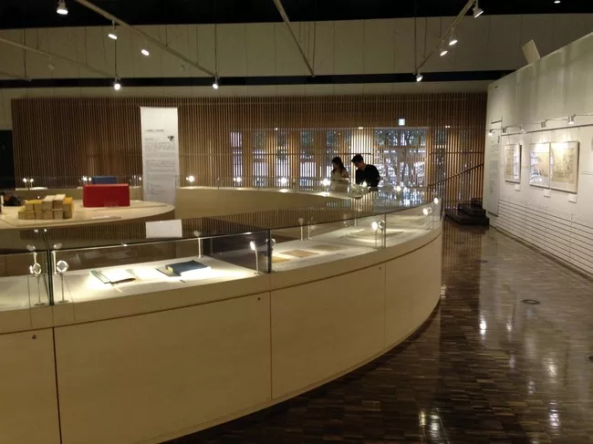 <p>The exhibition materials are displayed in a series of curved vitrines that form a circle within the main room of the Archives building.</p><div id='_mcePaste'>