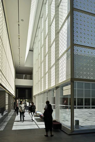 The geometric mashrabiya pattern printed on the glass walls of the interior courtyard cast intricate shadows inside the museum.