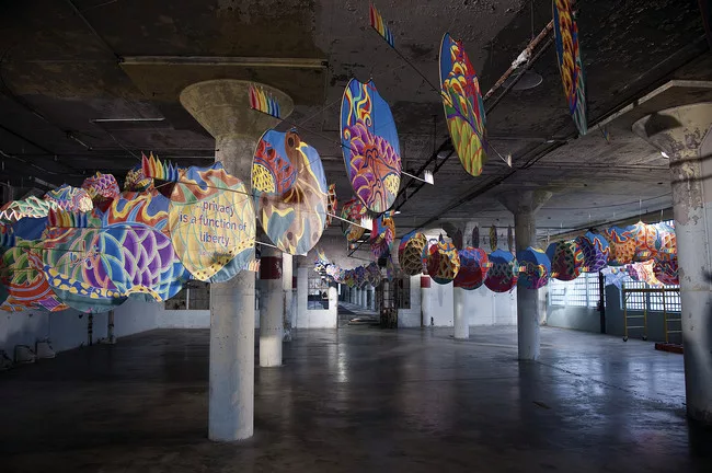 The patterns in <em>With Wind</em>'s fabric include renderings of birds and flowers representing nations that have severely restricted human rights and civil liberties, among them Cameroon, China, Rus