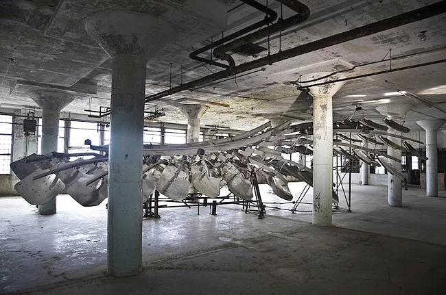 In the dank lower level of the New Industries Building, the bird of freedom is not merely tethered like a kite, but virtually leaden. Here, <em>Refraction</em> presents an abstract bird wing, weighing