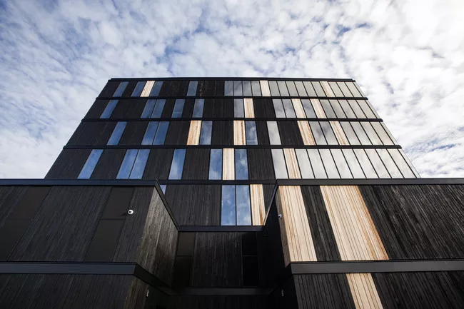 The building is clad in cedar that has been charred to reduce flame spread.