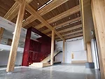 The timber post-and-beam structure is visible throughout the WIDC, including the double-story foyer.