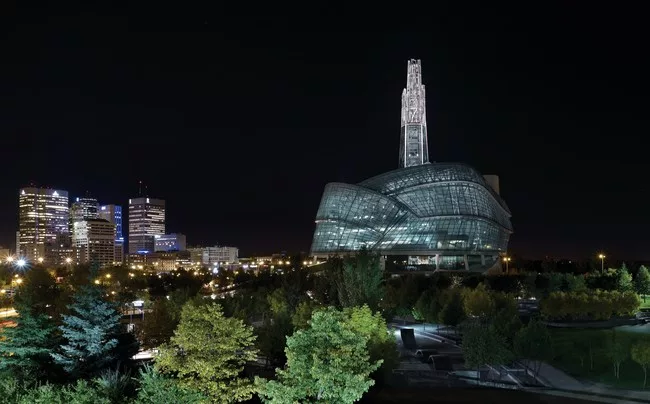 The glass atrium, facing southwards, illuminates at night.