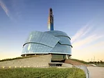 Visitors enter through the museum’s base, walking past the Roots, sloping structures meant to represent humanity’s link to the earth. The Roots contain classrooms, ticketing, a restaurant,