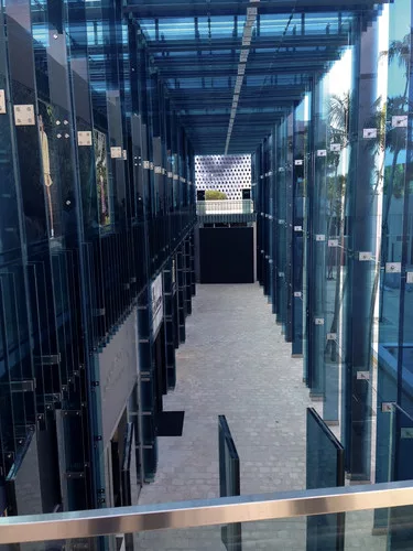 Sou Fujimoto’s two-story porch, made of sheets of thick blue glass, provides a facade for the half a dozen stores under construction behind it.<div id='_mcePaste'>
