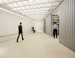 The Van Alen's new storefront space in Manhattan's Flatiron district joins a large event space to a series of alcoves that can be hidden behind accordion doors during public programs.<div id='_mcePast
