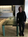 Designer Vincent van Duysen beside his new table for B&B Italia, inside the furniture company's showroom on Via Durini.