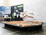The six finalist designs are suspended over a model of Helsinki.