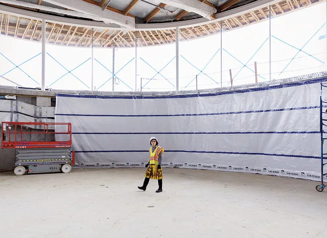 Kazuyo Sejima of SANAA inspects the construction progress inside the gymnasium in late March. The double-story space is sunk one level below grade in order to minimize its impact on the landscape.<div