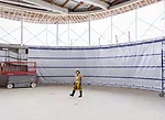 Kazuyo Sejima of SANAA inspects the construction progress inside the gymnasium in late March. The double-story space is sunk one level below grade in order to minimize its impact on the landscape.<div