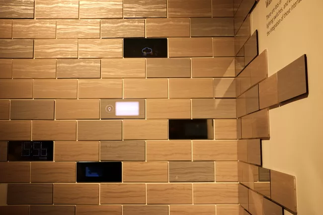Conceptual wall tiles by Nissha transform with the touch of a finger from a marble stone or mirror finish to a digital interface where users can adjust temperature or access other home applications co