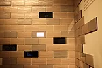 Conceptual wall tiles by Nissha transform with the touch of a finger from a marble stone or mirror finish to a digital interface where users can adjust temperature or access other home applications co