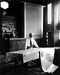 Frank Lloyd Wright stands at the drafting table in his studio at Taliesin, Wisconsin, 1947, photographed by Pedro E. Guerrero.