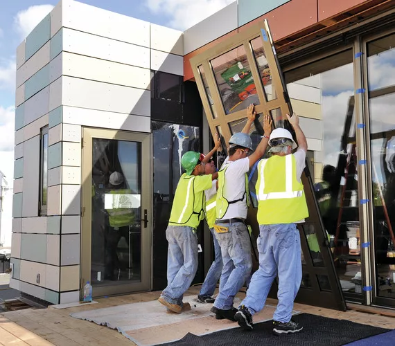 The combined team of Crowder College and Drury University install hurricane-resistant doors on their house.