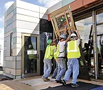 The combined team of Crowder College and Drury University install hurricane-resistant doors on their house.