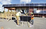 Team members from the New York City College of Technology install solar panels on their house.