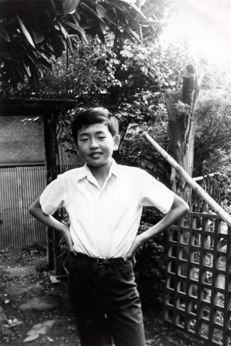 A young Kengo Kuma in front of his home.