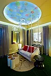A swinging sofa with lucite rods is the centerpiece of <i>The Big C</i>, 'Clarity Lounge,' by Francesca Bucci and Hans Galutera. Other whimsical details include a Swarovski ceiling fixture, a compass 