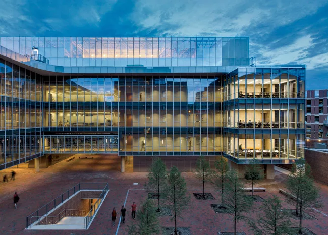 The labs are enclosed in three distinct yet connected glass-and-concrete pods. These elements hover above a raised brick plaza through which thousands of university members pass each day. A wi