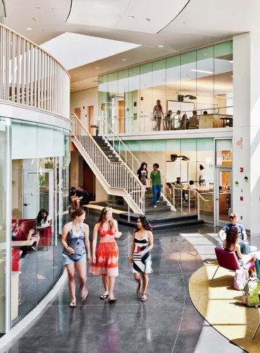 Open stairways in the double-height corridor, and floor-to-ceiling glass walls between classrooms and public spaces, create an airy yet intimate environment.