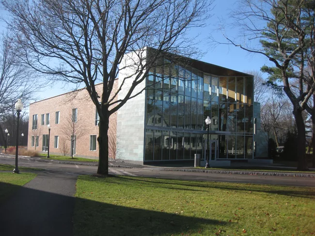 The headmaster's house reflects off of the science center's front facade.