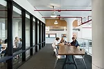 Double-height windows, exposed by a cut in the slab, fill a shared middle/high-school project room and common gathering space with ample daylight. The interior designers juxtapose tradition and innova