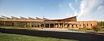 To fit in with the local tradition of rustic lodges and farm structures, the architects used a sawtooth roof over the gym and cedar siding above the main entry.