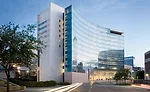 Shoehorned onto a highly compressed lot, the building form became as much about site coverage as about program; the signature bowed glass front was a response to the property line, which hugs the curv