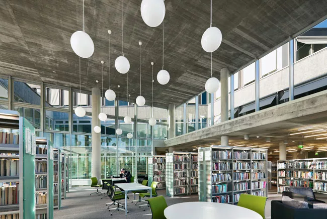 Sunlight fills a double-height reading room thanks to glass walls and clerestory windows. The architects worked with engineers at Transsolar so the entire complex could be naturally ventilated.