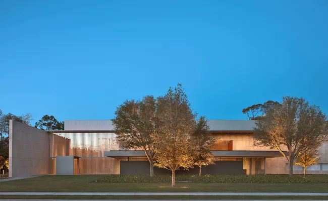 Rose-colored light reflects off the facade’s Jura limestone and slender, channel-glass-like windows with aluminum mullions.