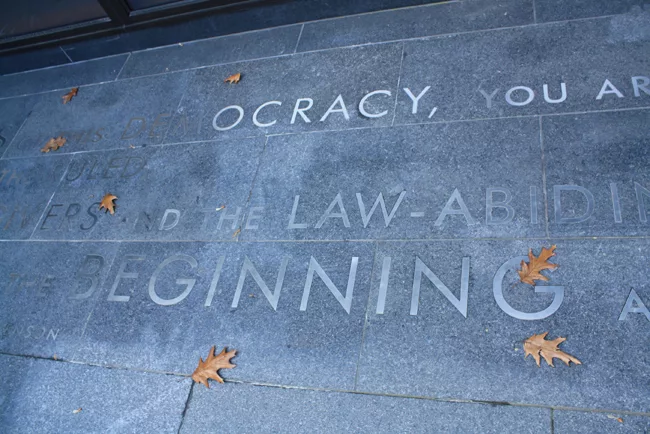 A quote from Adlai E. Stevenson in the brushed granite slabs in the courtyard: 'As citizens of this democracy, you are the rulers and the ruled, the lawgivers and the law-abiding, the beginning and th