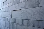 The recycled marble cladding is set unevenly in the fa'ade.