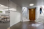 In the reorganized basement, walls of frosted and clear glass define conference rooms and offices.