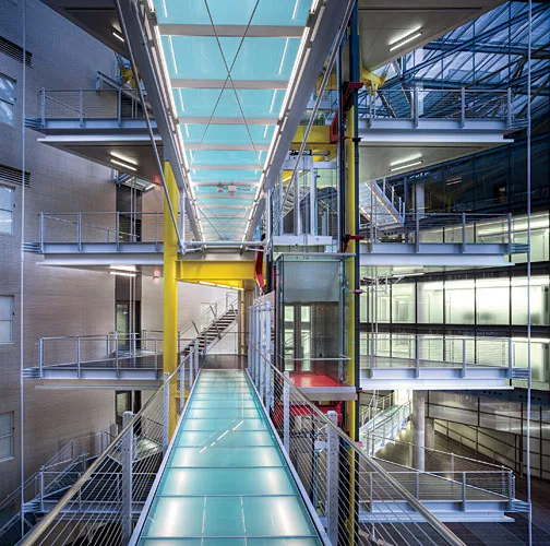 A series of glass bridges, backlit by lines of T5 lamps, link office spaces.