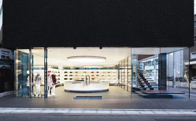 Made of a translucent formable material supported by a polished stainless steel frame, the shop&rsquo;s oversize elliptical luminaire hovers above a glowing cash/wrap station and illuminates the acces