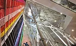 The architects inserted a shard of glass and steel through the floor plates as a conduit for dramatic lighting, views, and mannequins rotating on theatrical rigging.
