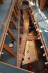A large trapezoidal skylight in the floor of the first office level brings light into the center of the ground floor caf' below it, as well as through a second skylight that continues the flow of ligh