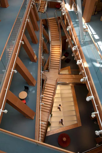 A large trapezoidal skylight in the floor of the first office level brings light into the center of the ground floor caf' below it, as well as through a second skylight that continues the flow of ligh