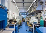 Direct lighting fixtures attached to a suspended raceway provide illumination for the central zone of each lab.
