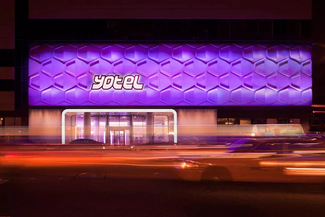 A strip of linear LEDs installed at the top and bottom of precast-concrete facade panels emphasize the cladding's relief pattern.