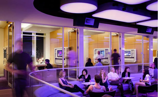 The Rockwell Group'designed Yotel has a daytime meeting room that transforms into a bar at night. To accommodate both uses, ceiling panels backlit with color-changing LEDs can fill the space with eith