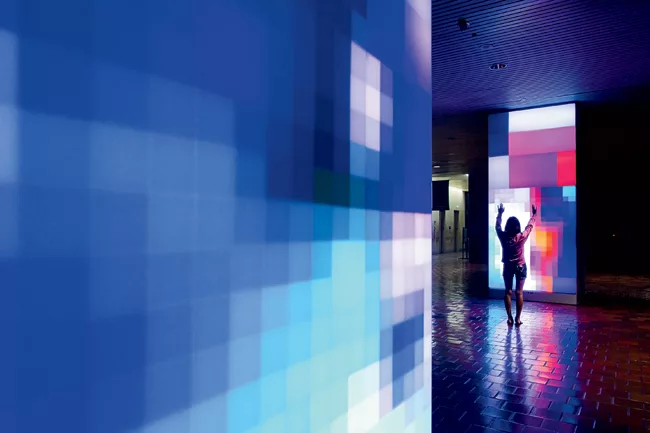 The interactive work enlivens the lobby of a busy civic building and bounces its vivid hues off the surfaces of the floor and ceiling.